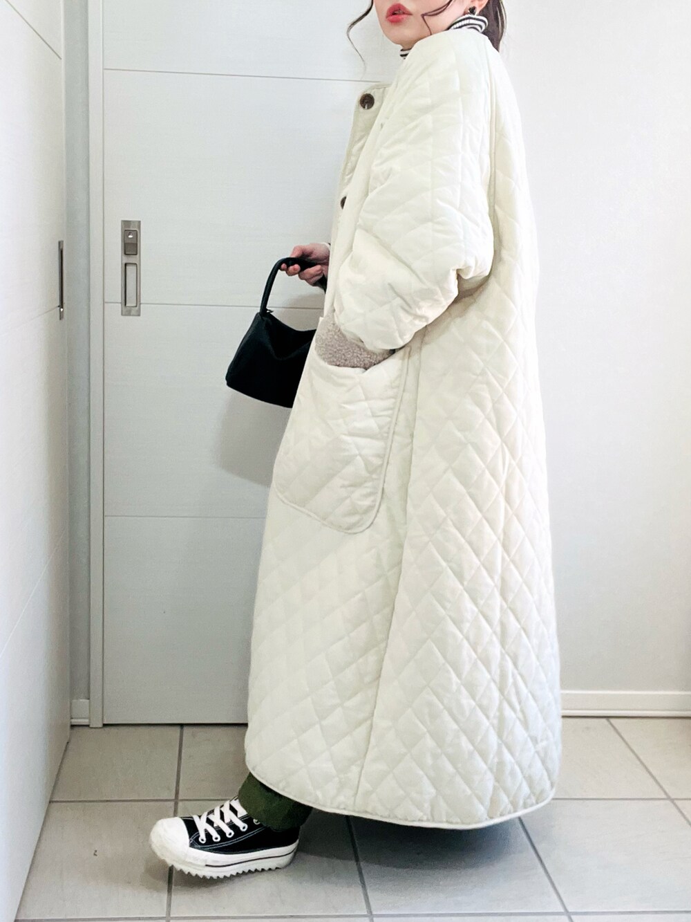 ホワイト系のその他アウター、その他のニット/セーター、ブラック系のスニーカーを着用したレディースの秋コーディネートの4枚目の写真