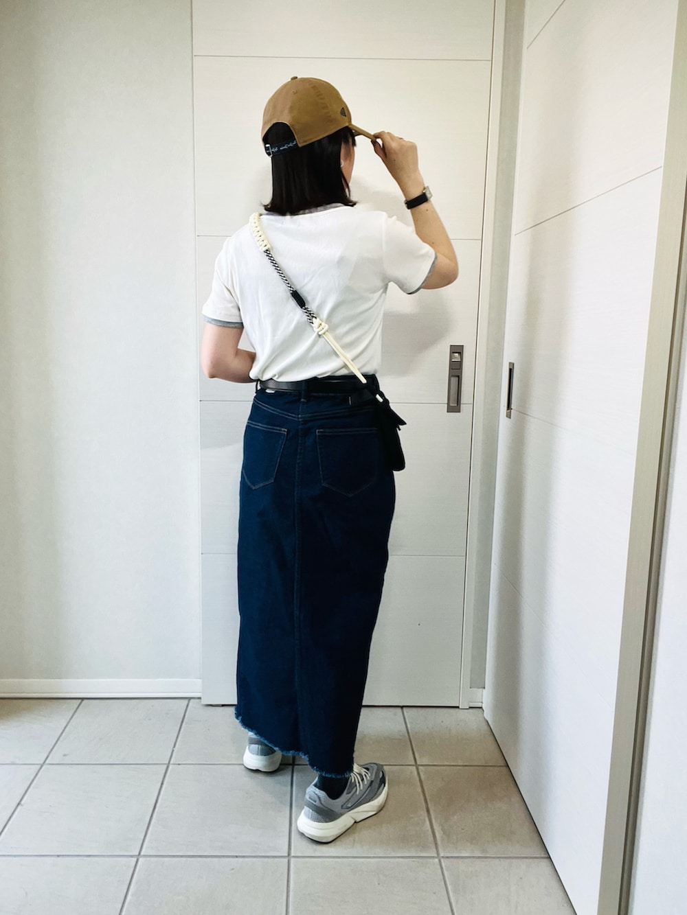 ホワイト系のTシャツ/カットソー、ブルー系のスカート、グレー系のスニーカーを着用したレディースの春コーディネートの5枚目の写真