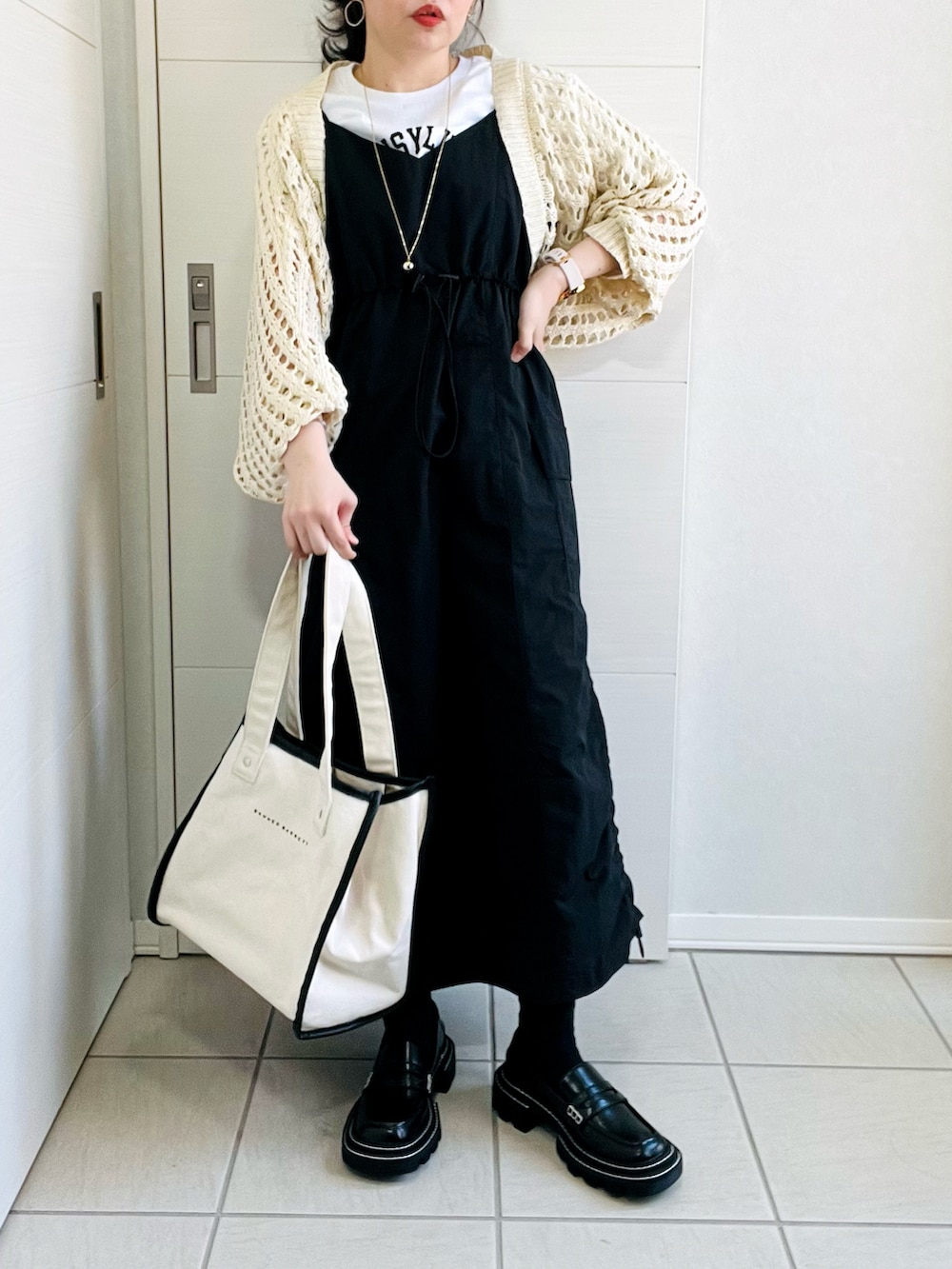 ホワイト系のカーディガン/ボレロ、ホワイト系のTシャツ/カットソー、ブラック系のワンピースを着用したレディースの春コーディネートの4枚目の写真