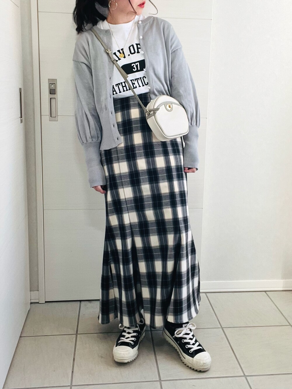 グレー系のカーディガン/ボレロ、ホワイト系のTシャツ/カットソー、ブラック系のスカートを着用したレディースの冬コーディネートの3枚目の写真