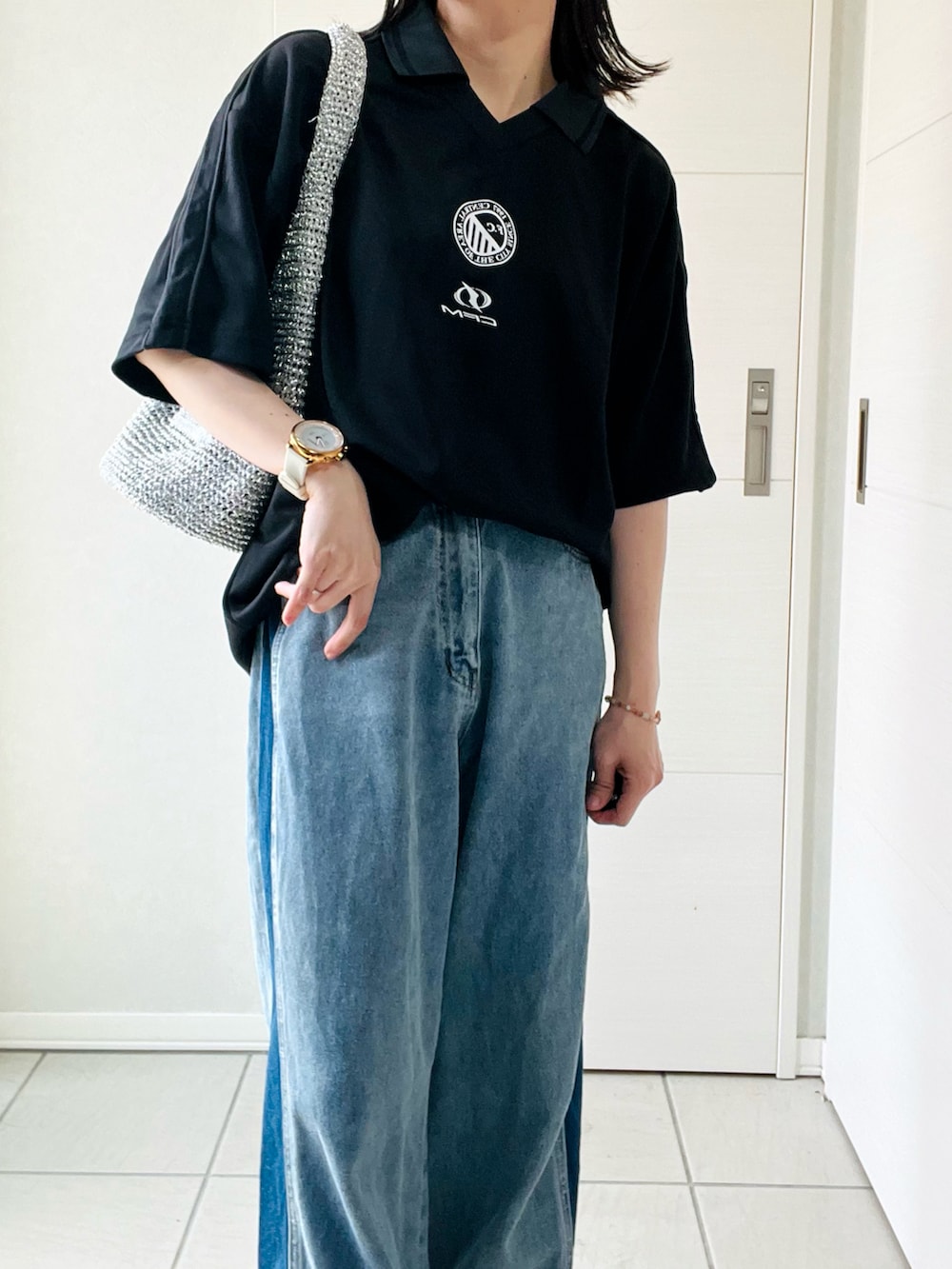 ブラック系のTシャツ/カットソー、ブルー系のデニムパンツ、レッド系のスニーカーを着用したレディースの夏コーディネートの2枚目の写真