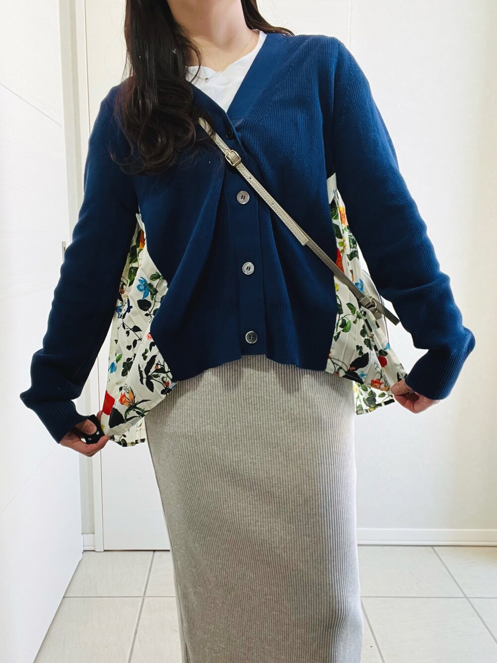 ブルー系のカーディガン/ボレロ、ベージュ系のスカート、ホワイト系のスニーカーを着用したレディースの春コーディネートの4枚目の写真