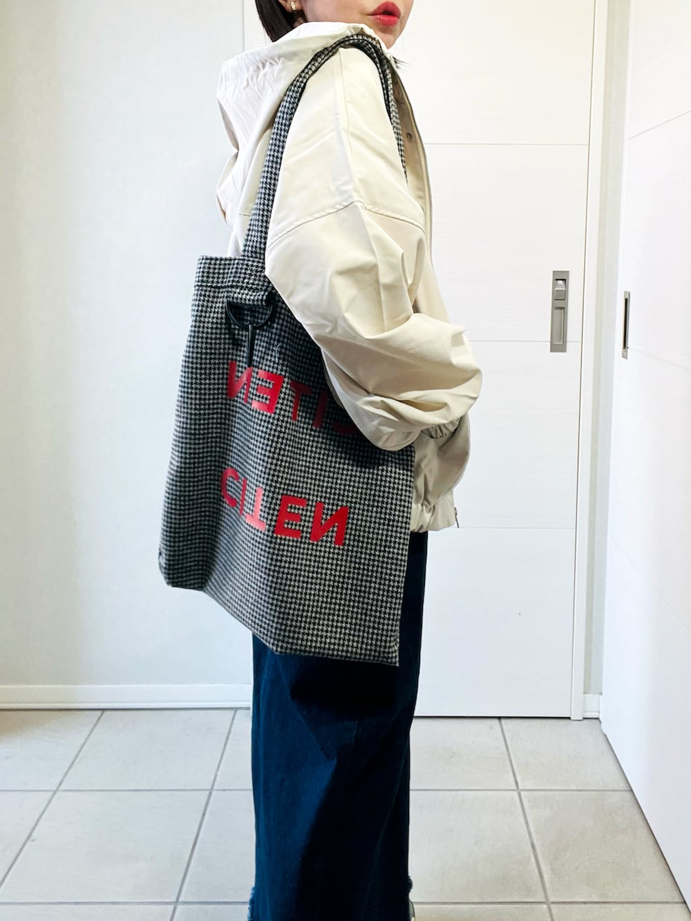 ホワイト系のマウンテンパーカー、グレー系のスニーカー、ホワイト系のTシャツ/カットソーを着用したレディースの春コーディネートの3枚目の写真