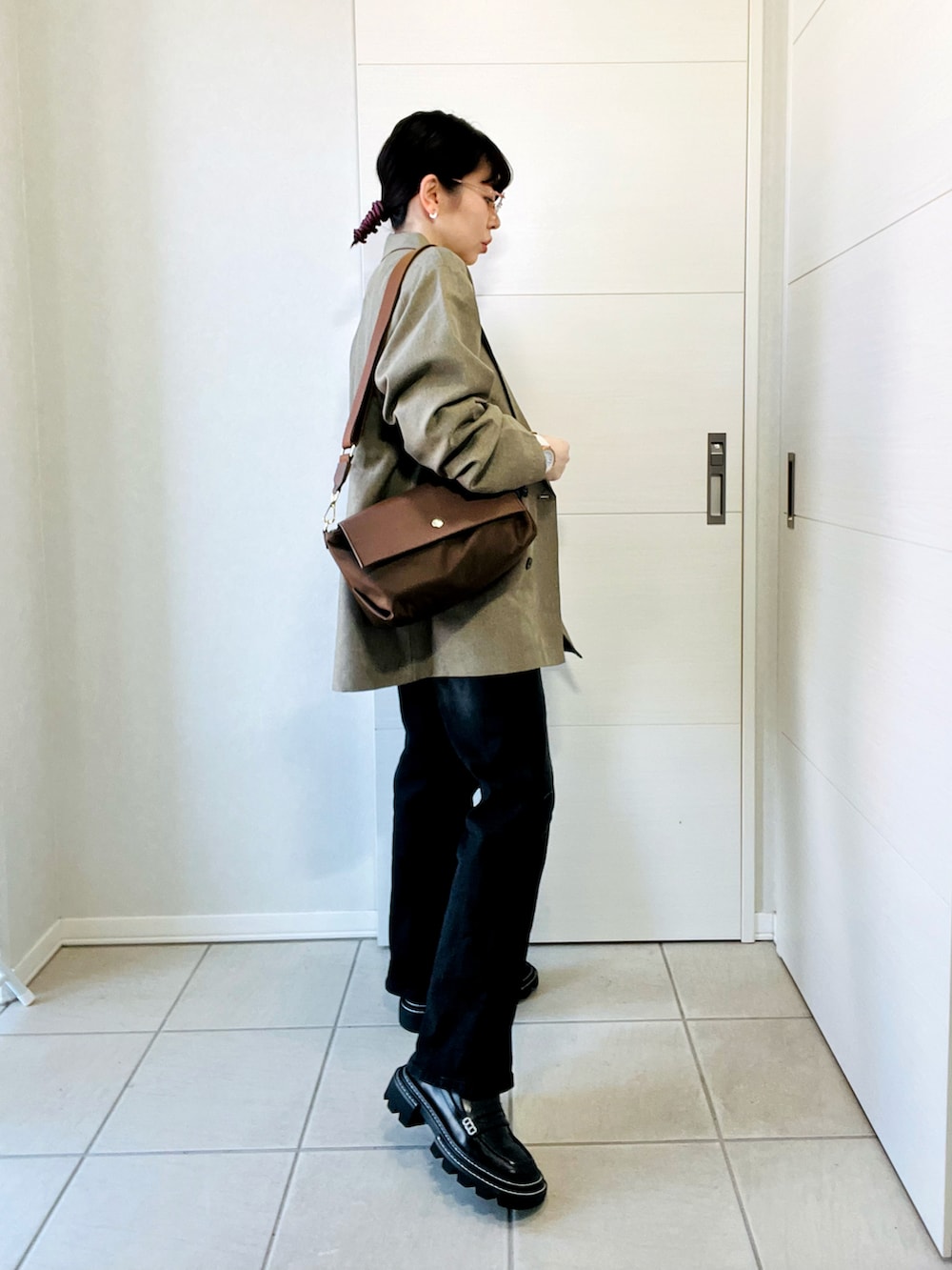 ベージュ系のテーラードジャケット、ベージュ系のスウェット、ブラック系のデニムパンツを着用したレディースの春コーディネートの5枚目の写真