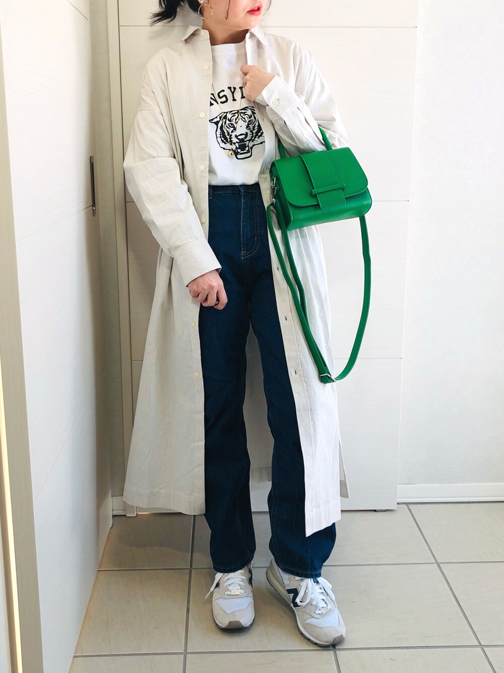 ベージュ系のワンピース、ホワイト系のTシャツ/カットソー、ブルー系のデニムパンツを着用したレディースの冬コーディネートの3枚目の写真