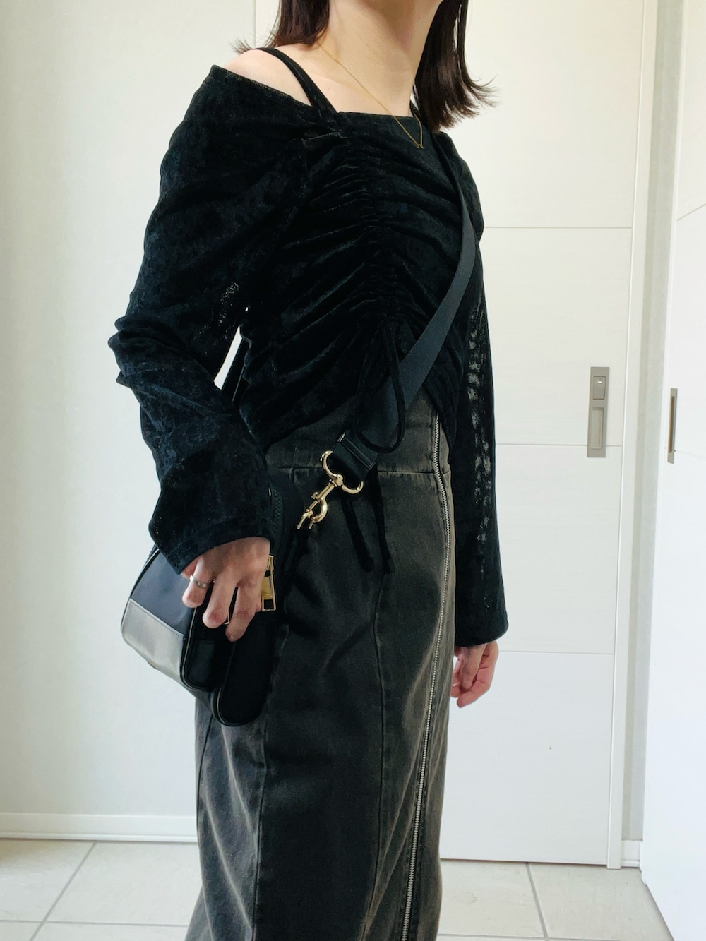 ブラック系のTシャツ/カットソー、ブラック系のブーツ、ブラック系のスカートを着用したレディースの秋コーディネートの3枚目の写真