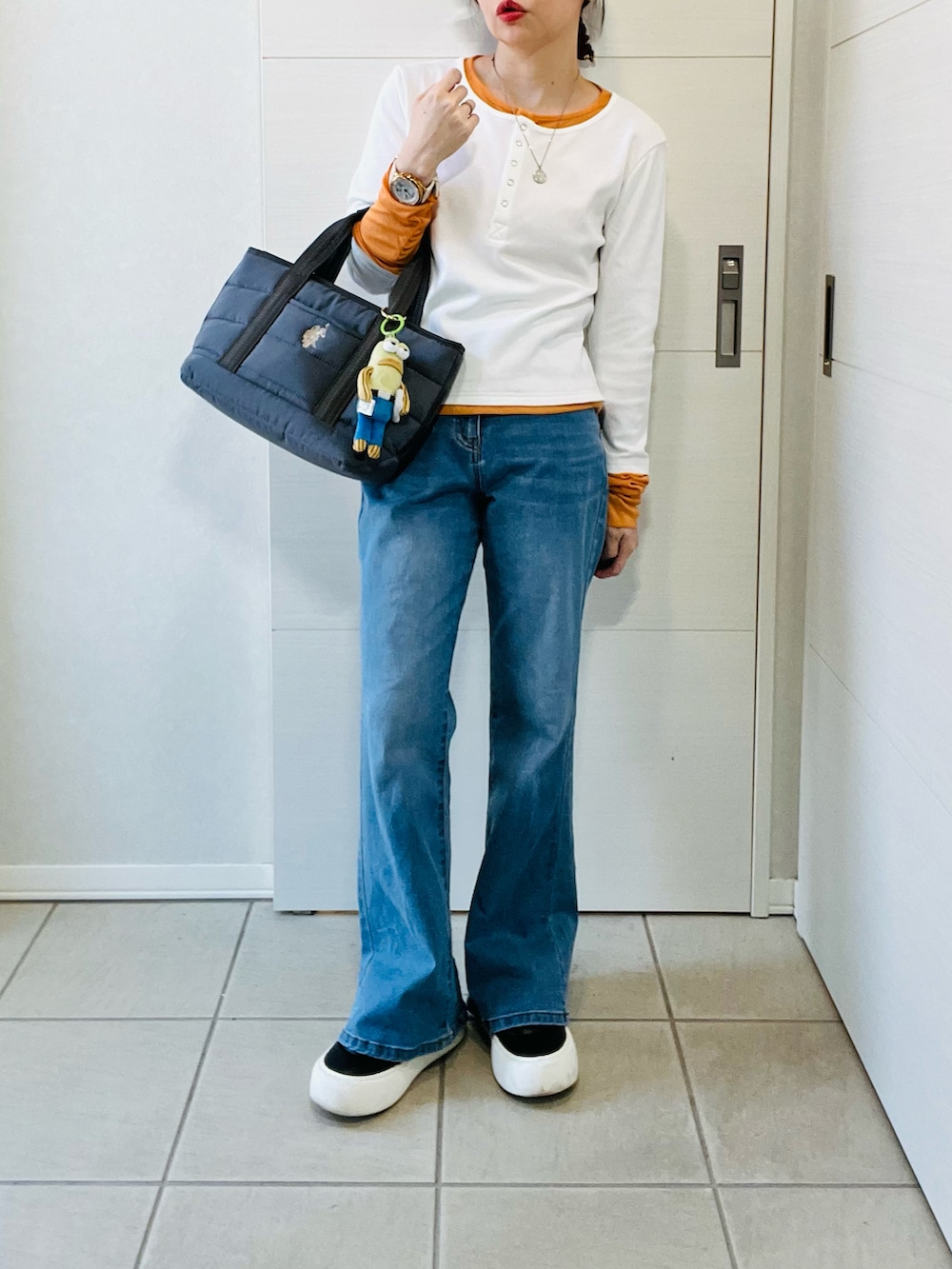 ブルー系のデニムパンツ、ホワイト系のTシャツ/カットソー、ブラック系のスニーカーを着用したレディースの春コーディネートの4枚目の写真