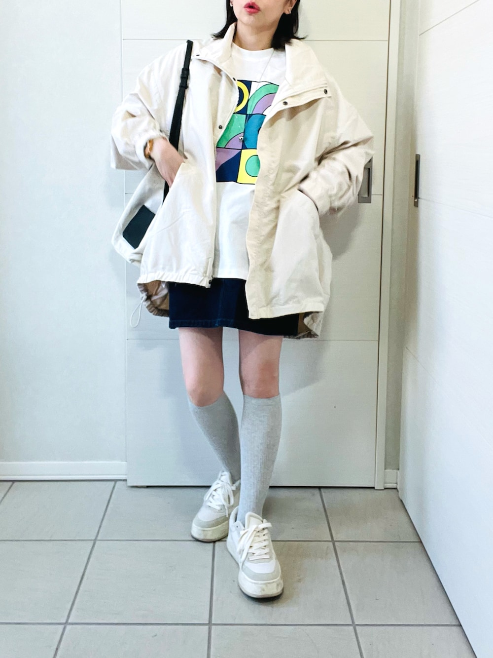 ホワイト系のナイロンジャケット、その他のTシャツ/カットソー、ブルー系のデニムスカートを着用したレディースの春コーディネートの4枚目の写真