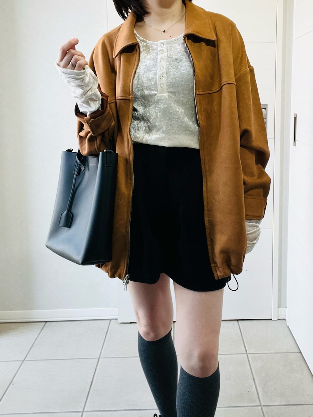 ホワイト系のTシャツ/カットソー、ベージュ系のブルゾン、ブラック系のスニーカーを着用したレディースの春コーディネートの3枚目の写真