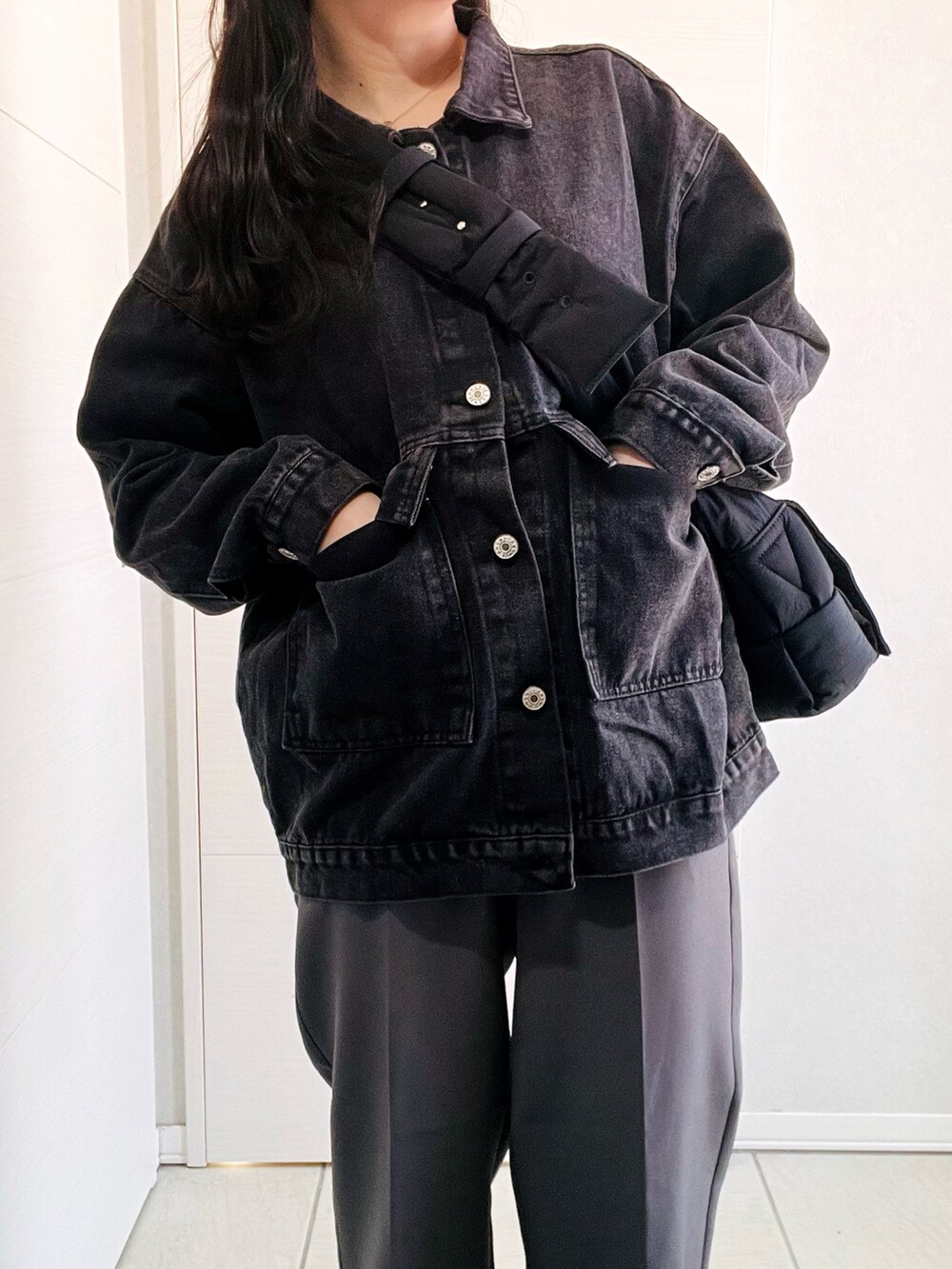 ブラック系のデニムジャケット、グレー系のスラックス、ブラック系のローファーを着用したレディースの春コーディネートの3枚目の写真