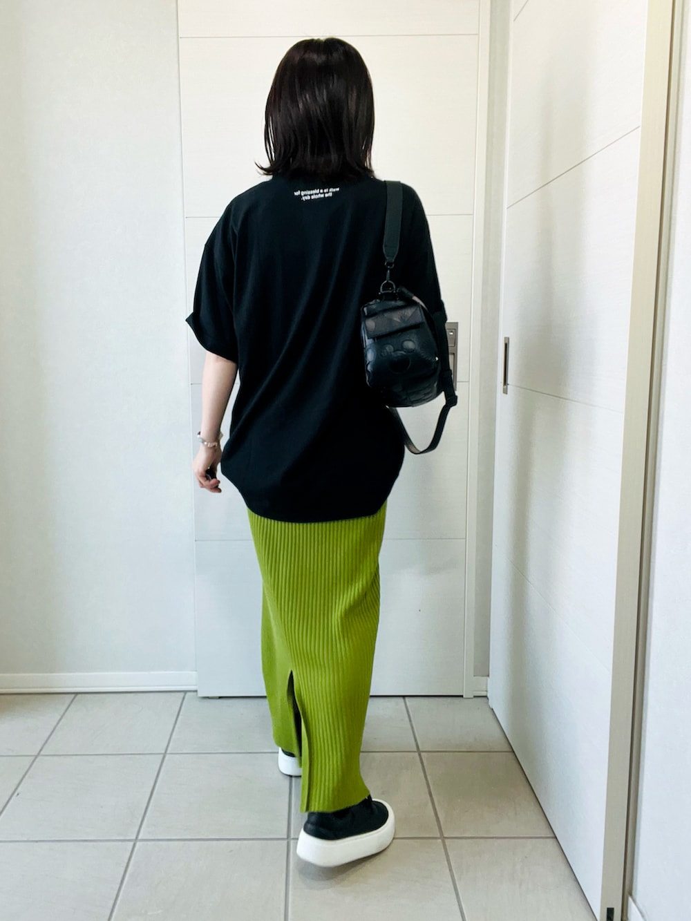 ブラック系のハンドバッグ、ブラック系のスニーカー、ブラック系のTシャツ/カットソーを着用したレディースの夏コーディネートの5枚目の写真