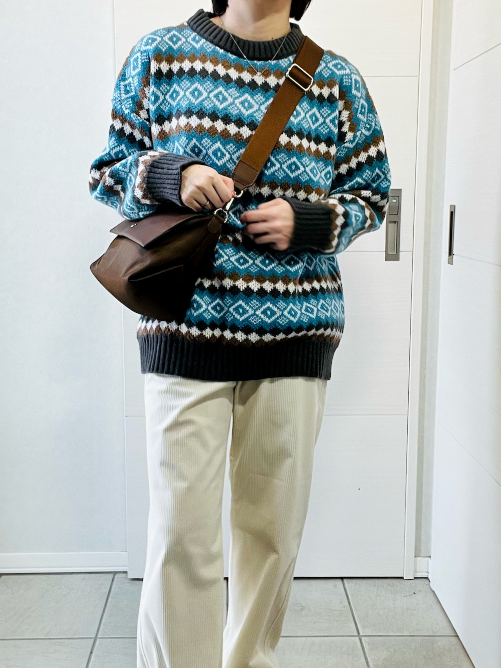 ホワイト系のその他パンツ、ブラウン系のブーツ、ブラウン系のショルダーバッグを着用したレディースの冬コーディネートの2枚目の写真
