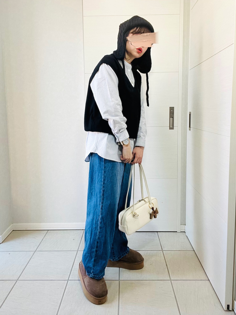 ブラック系のシャツ/ブラウス、ブルー系のデニムパンツ、ベージュ系のスリッポンを着用したレディースの秋コーディネートの5枚目の写真