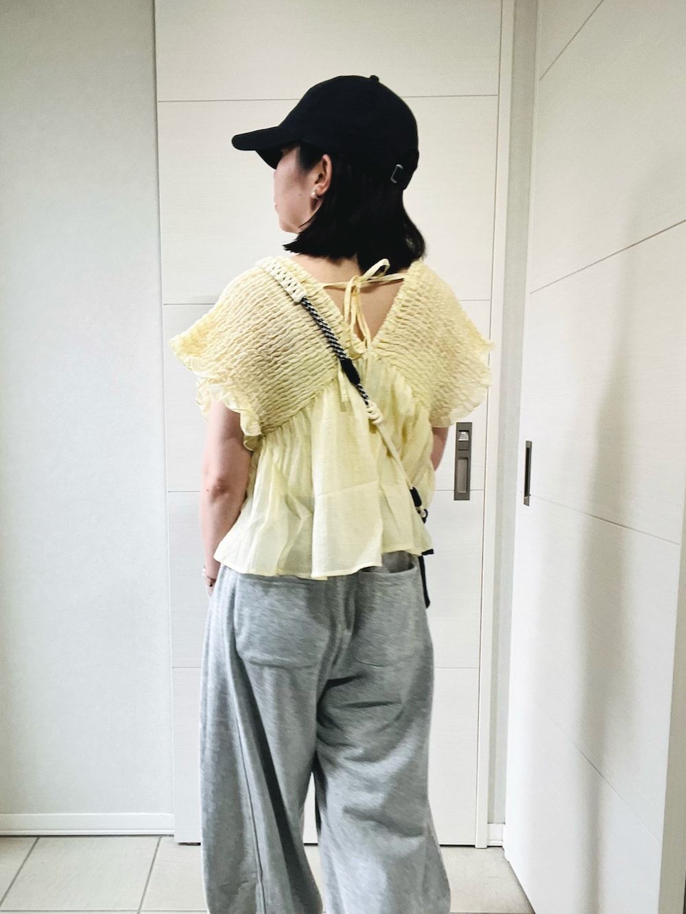 グレー系のスウェットパンツ、ホワイト系のスニーカー、イエロー系のシャツ/ブラウスを着用したレディースの夏コーディネートの2枚目の写真