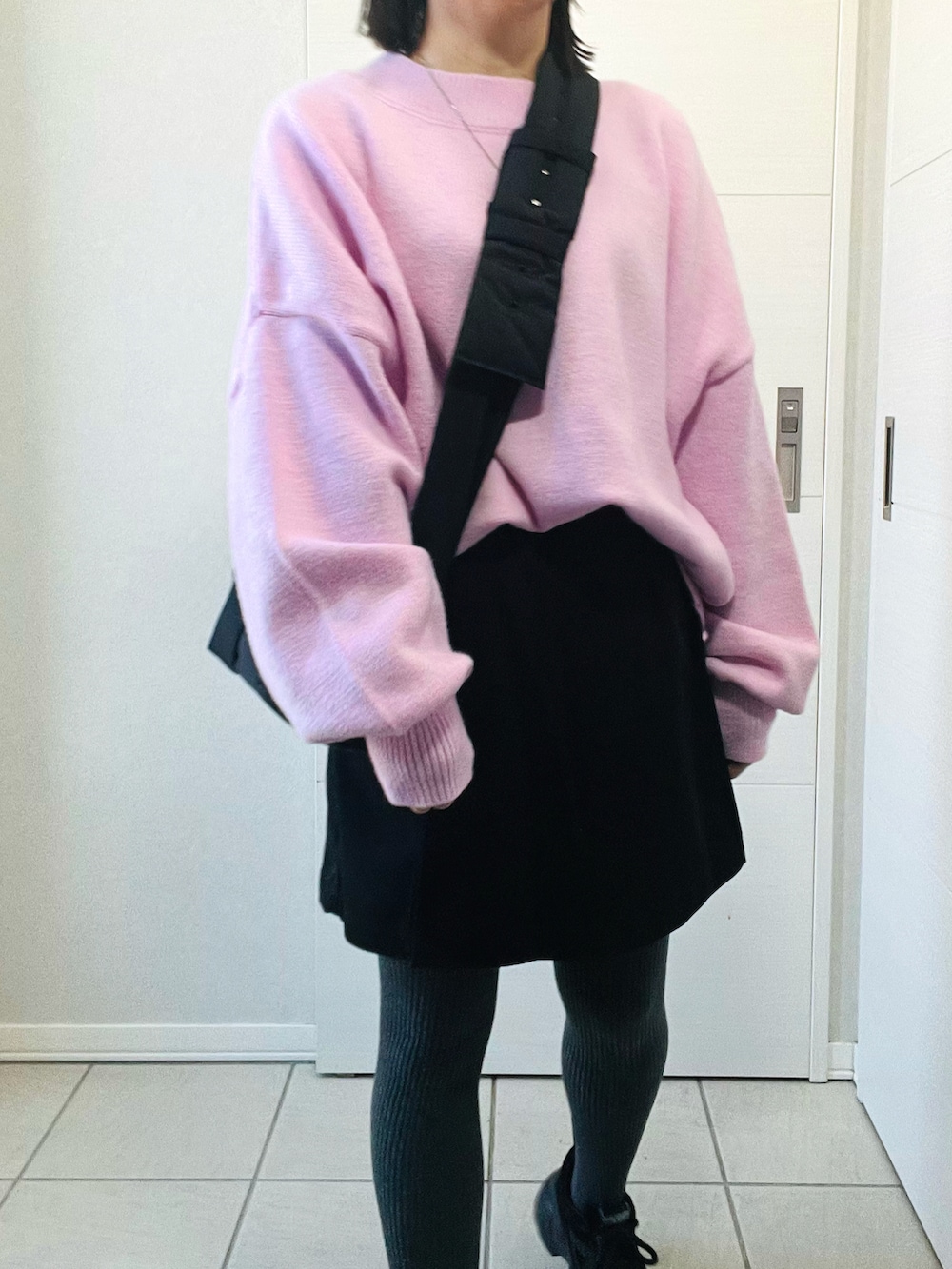 ピンク系のニット/セーター、ブラック系のその他パンツ、ブラック系のスニーカーを着用したレディースの冬コーディネートの2枚目の写真