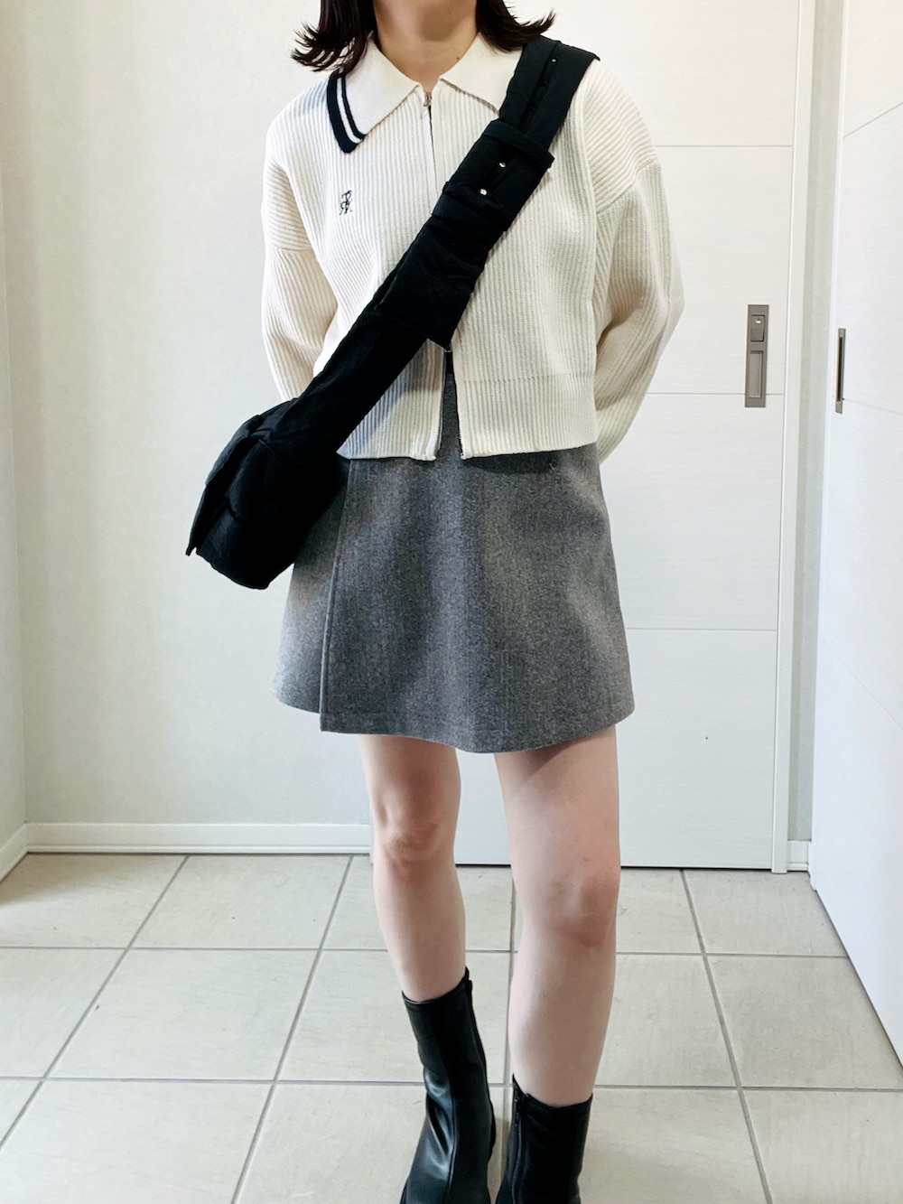 ホワイト系のニット/セーター、ブラック系のブーツ、グレー系のその他パンツを着用したレディースの秋コーディネートの2枚目の写真