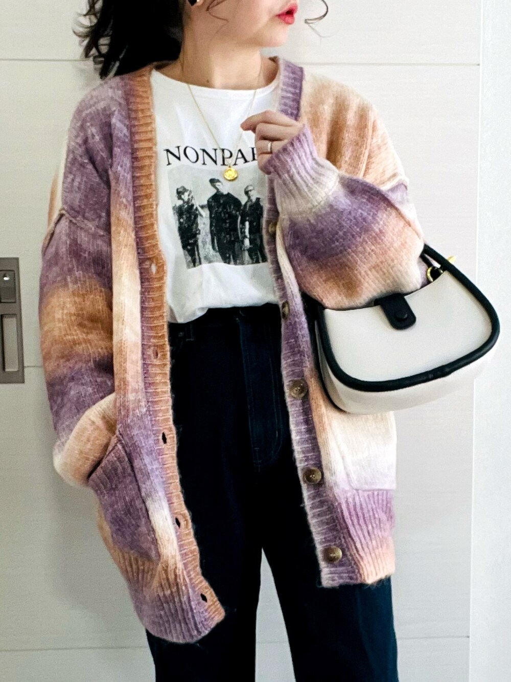 ブラウン系のカーディガン/ボレロ、ホワイト系のTシャツ/カットソー、ブルー系のデニムパンツを着用したレディースの冬コーディネートの2枚目の写真