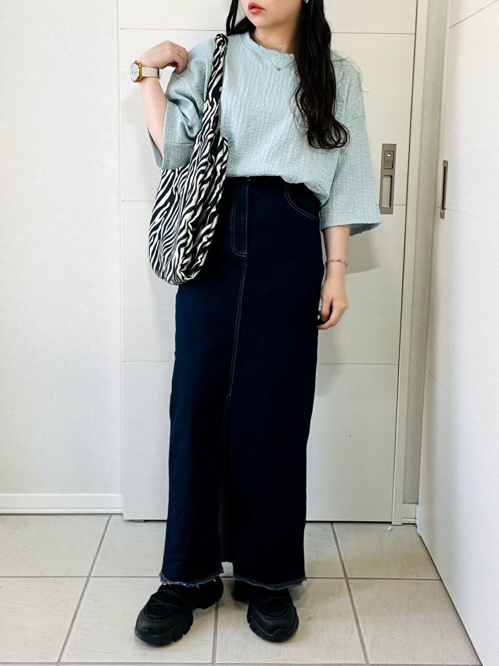 ブルー系のシャツ/ブラウス、ブルー系のデニムスカート、ブラック系のサンダルを着用したレディースの夏コーディネートの4枚目の写真