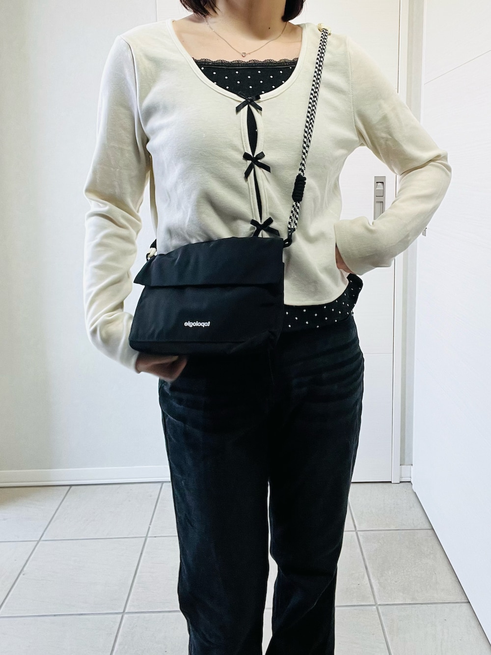 ホワイト系のTシャツ/カットソー、ブラック系のデニムパンツ、ブラック系のショルダーバッグを着用したレディースの春コーディネートの2枚目の写真