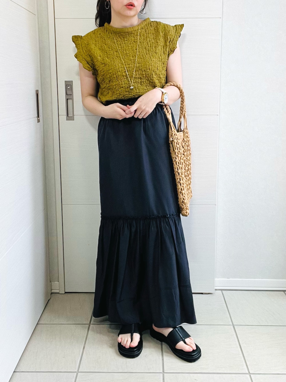 グリーン系のシャツ/ブラウス、グレー系のスカート、ブラック系のサンダルを着用したレディースの夏コーディネートの2枚目の写真