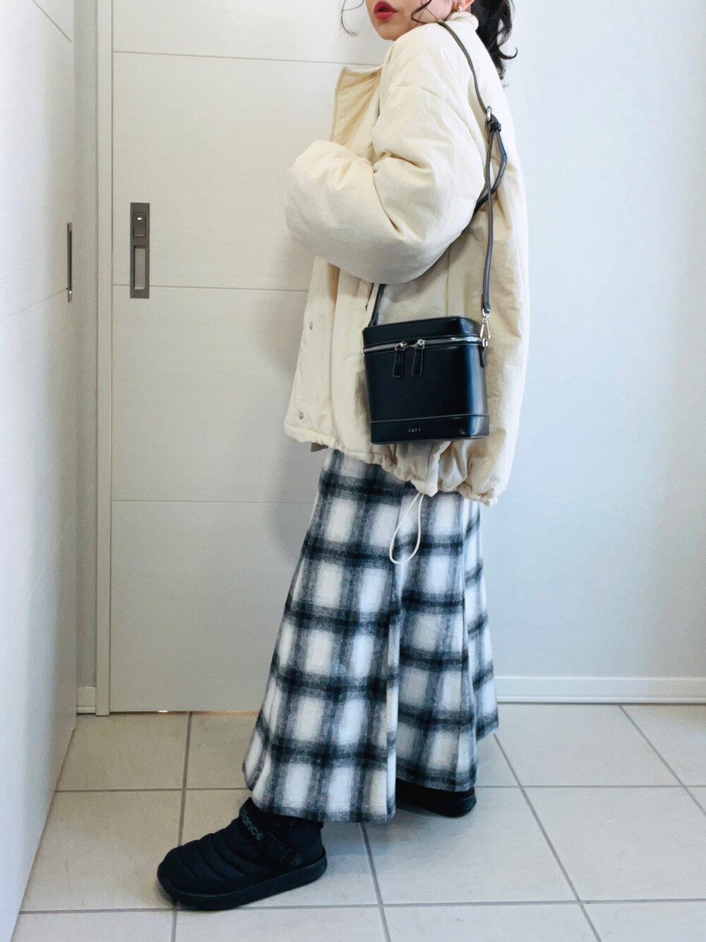 ホワイト系のブルゾン、ホワイト系のニット/セーター、ホワイト系のスカートを着用したレディースの冬コーディネートの5枚目の写真