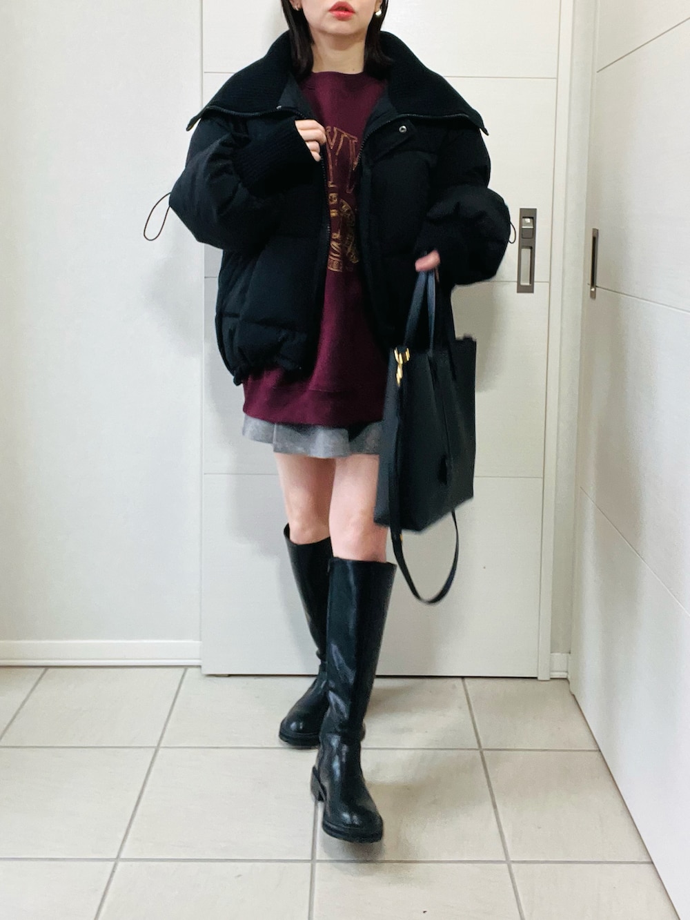 ブラック系のダウンジャケット/コート、レッド系のスウェット、グレー系のその他パンツを着用したレディースの冬コーディネートの3枚目の写真