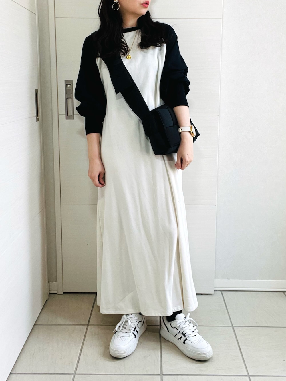 ホワイト系のワンピース、ホワイト系のスニーカー、ブラック系のショルダーバッグを着用したレディースの秋コーディネートの3枚目の写真