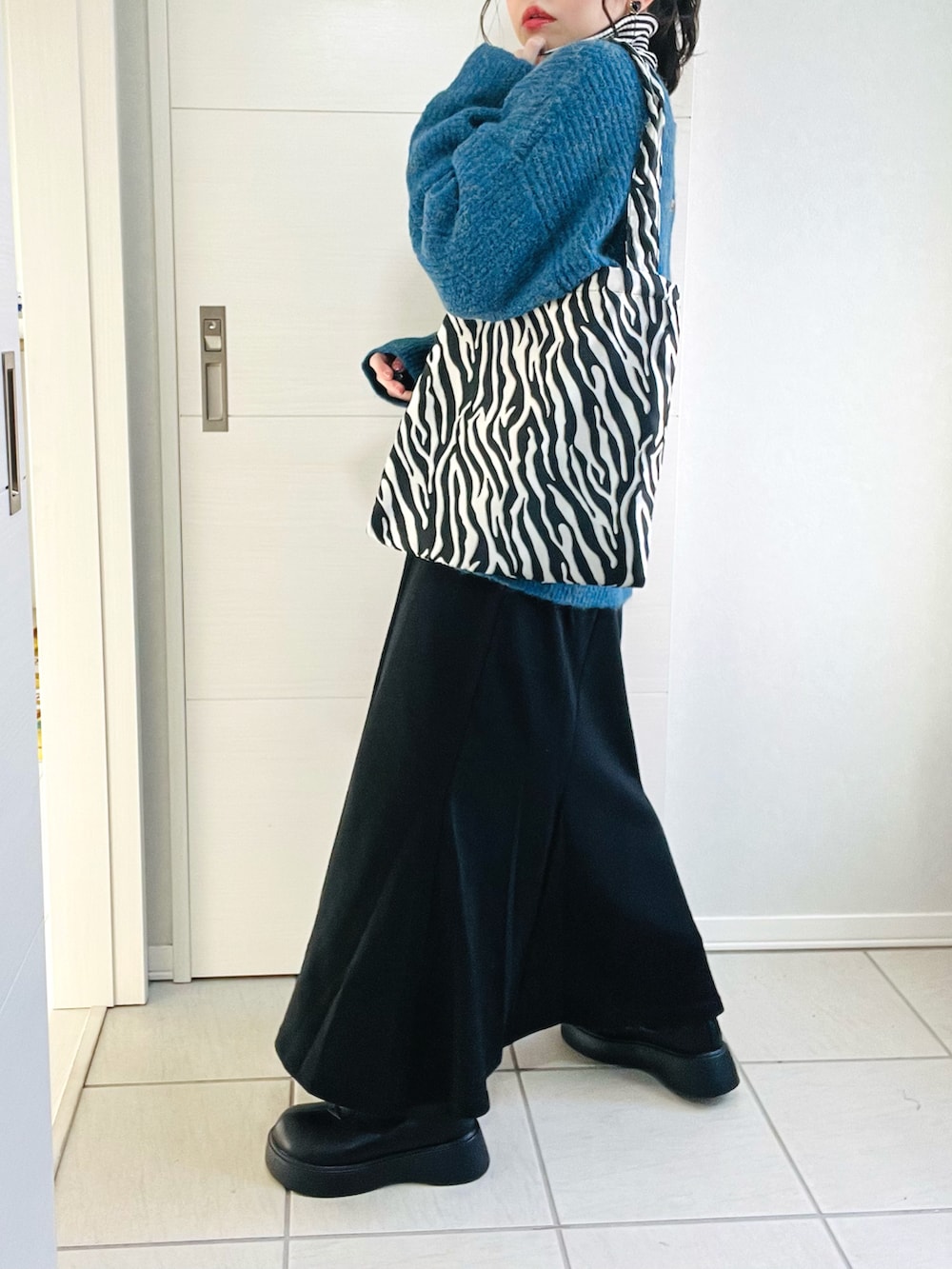 ブルー系のカーディガン/ボレロ、その他のニット/セーター、ブラック系のスカートを着用したレディースの秋コーディネートの4枚目の写真