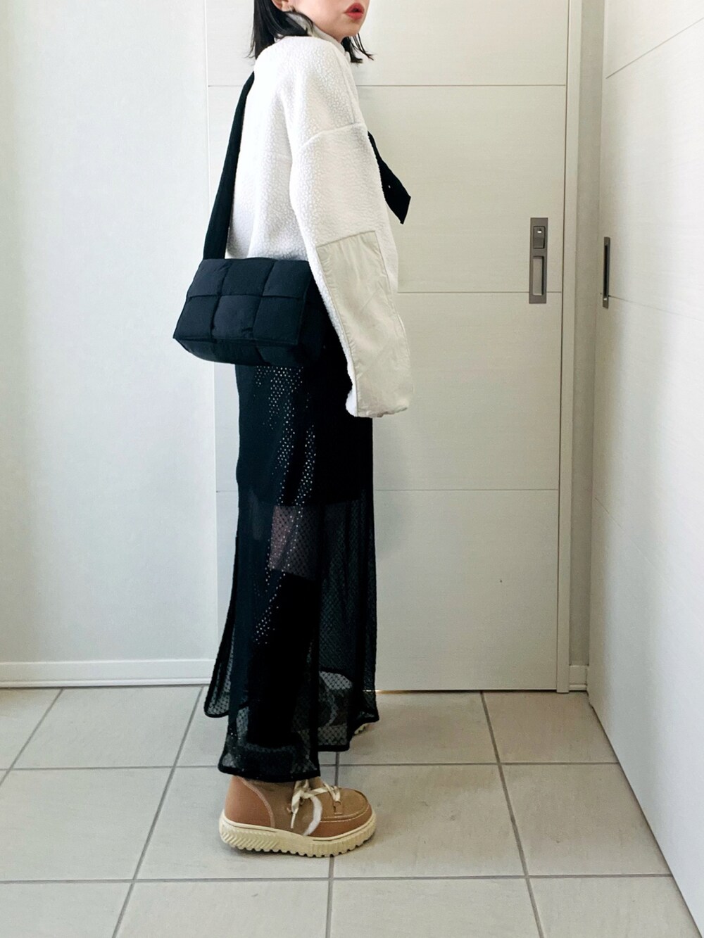 ホワイト系のTシャツ/カットソー、ブラック系のスカート、ブラウン系のブーツを着用したレディースの冬コーディネートの5枚目の写真