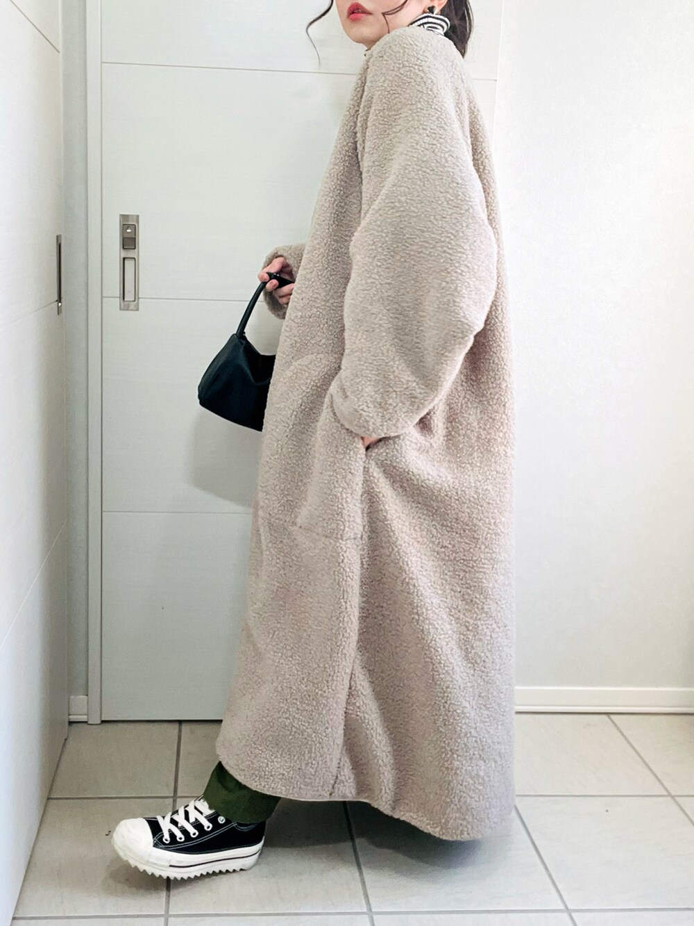 ホワイト系のその他アウター、その他のニット/セーター、ブラック系のスニーカーを着用したレディースの秋コーディネートの5枚目の写真