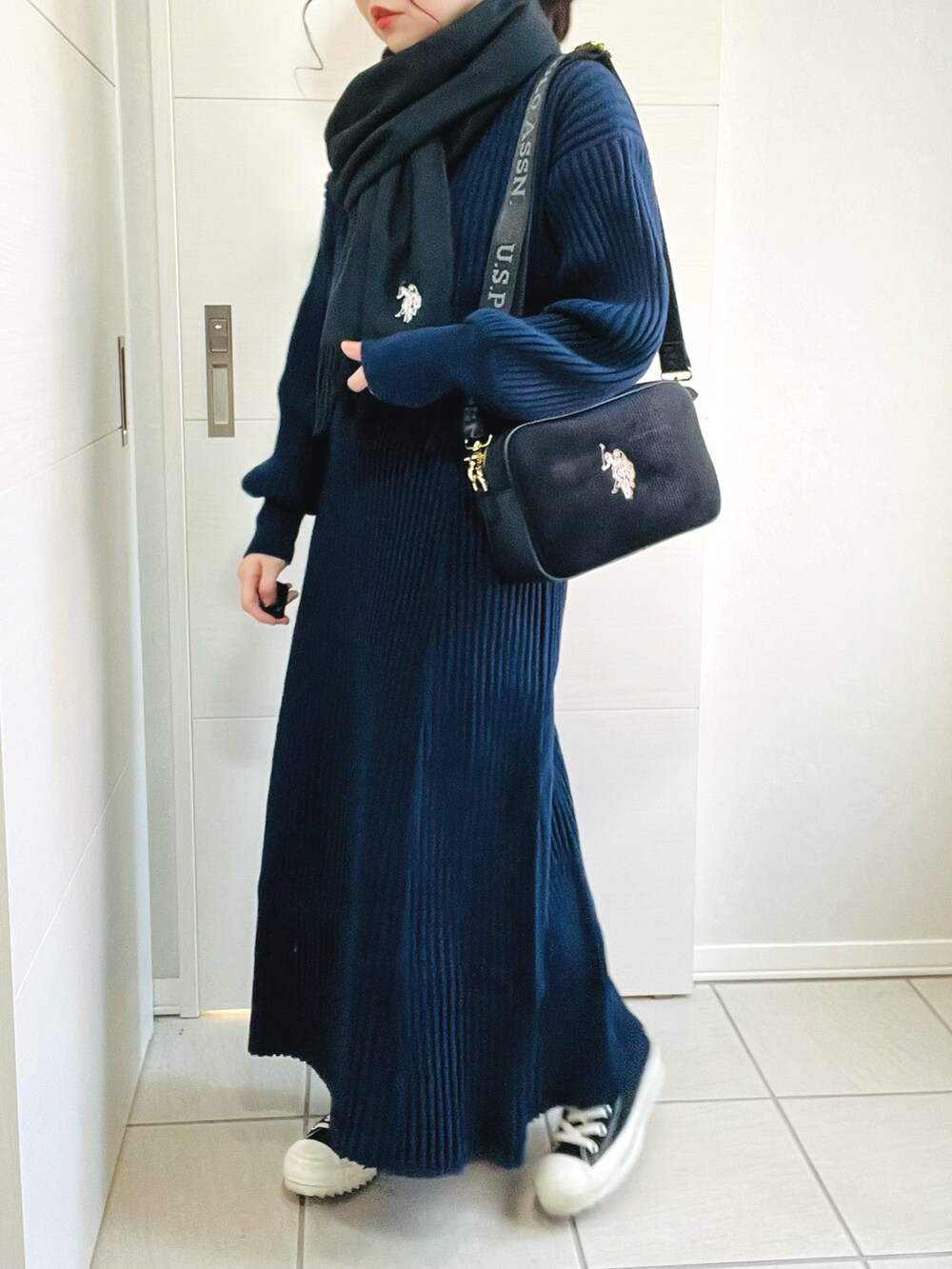 ブルー系のニット/セーター、ブルー系のスカート、ブラック系のスニーカーを着用したレディースの秋コーディネートの3枚目の写真