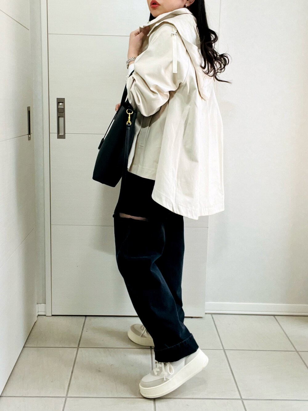 ホワイト系のマウンテンパーカー、ホワイト系のTシャツ/カットソー、ブラック系のデニムパンツを着用したレディースの春コーディネートの5枚目の写真