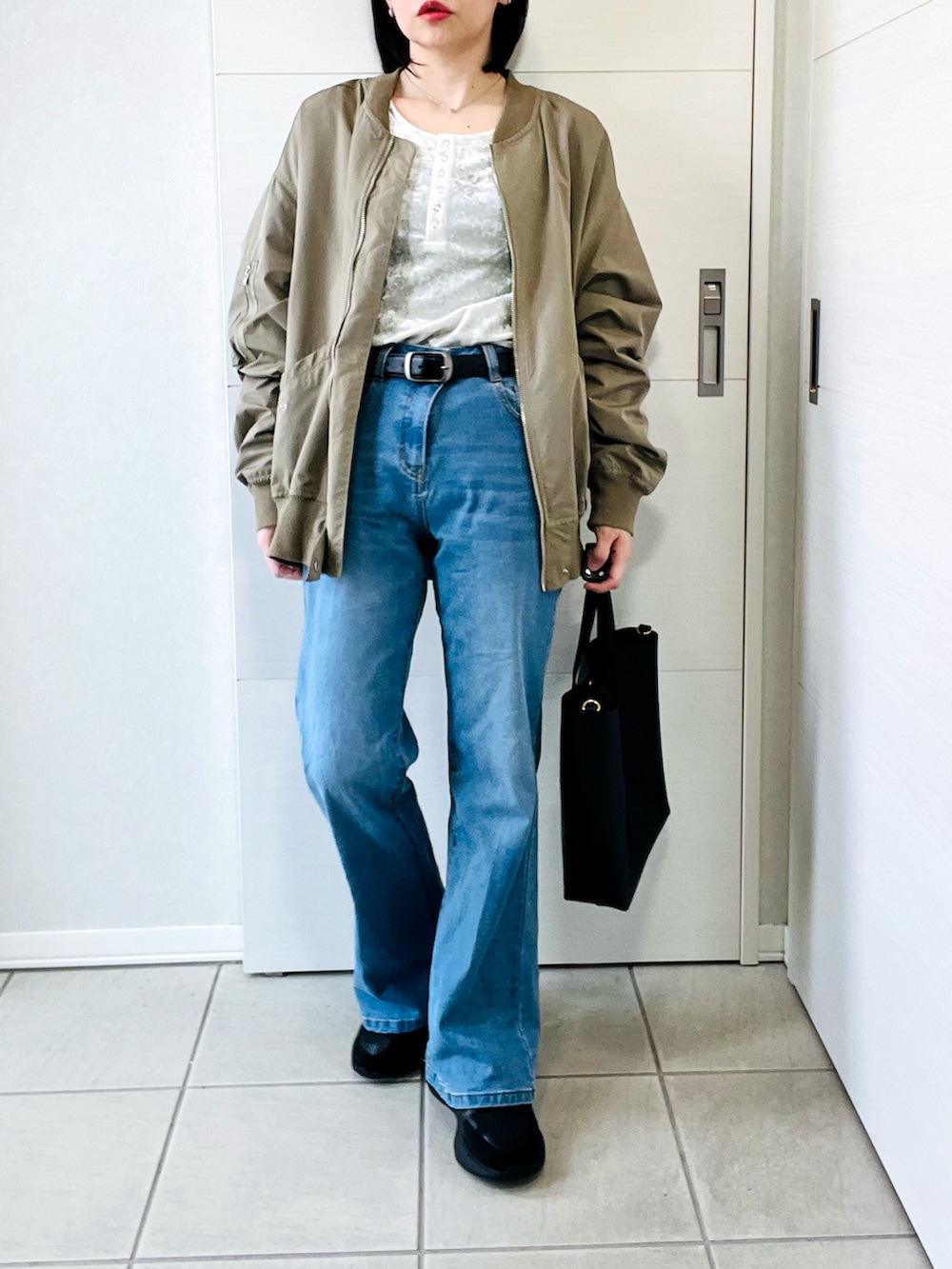 ホワイト系のTシャツ/カットソー、グリーン系のMA-1、ブルー系のデニムパンツを着用したレディースの春コーディネートの5枚目の写真