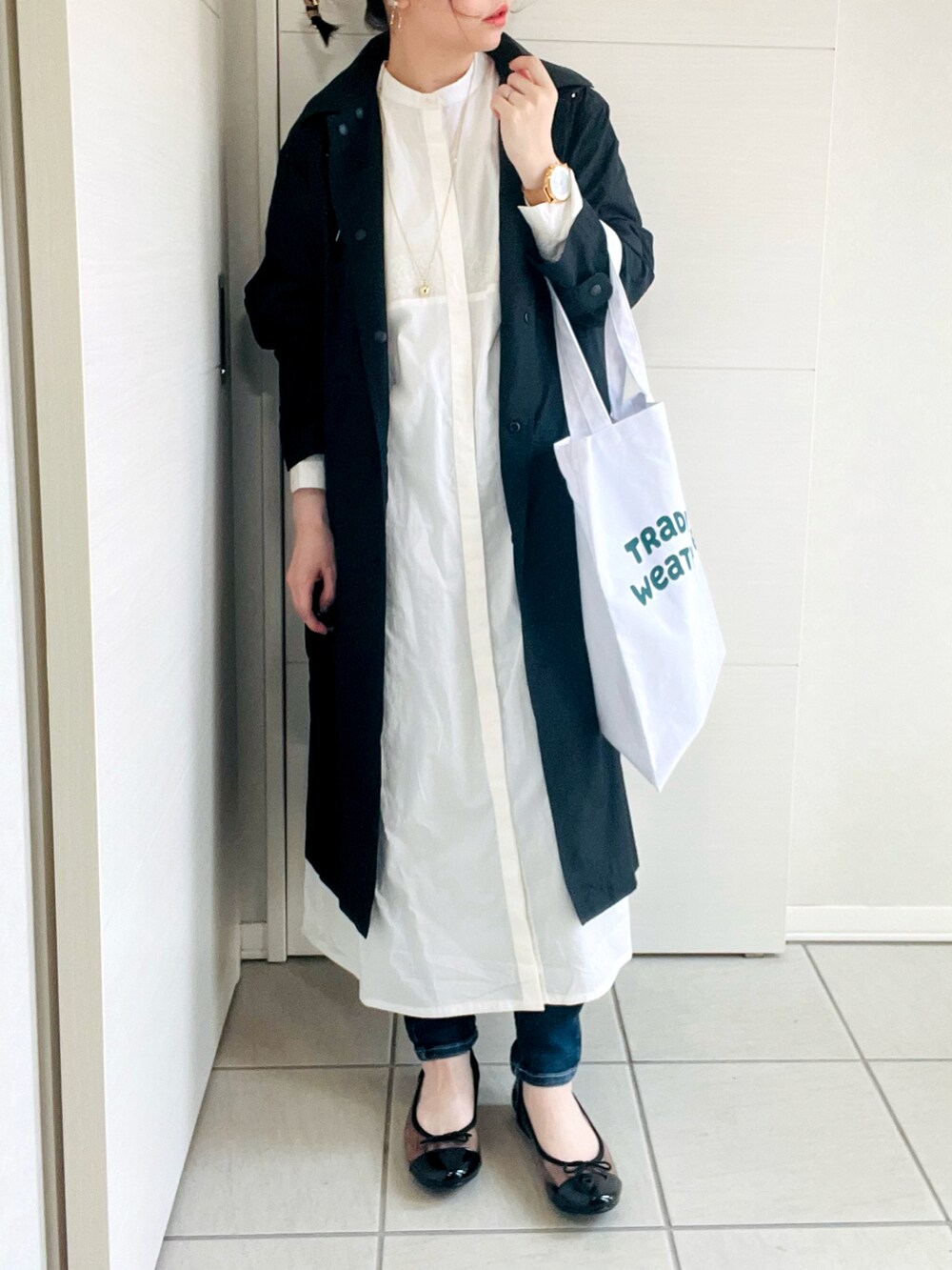 ホワイト系のシャツワンピース、ブラック系のバレエシューズ、ホワイト系のトートバッグを着用したレディースの春コーディネートの3枚目の写真