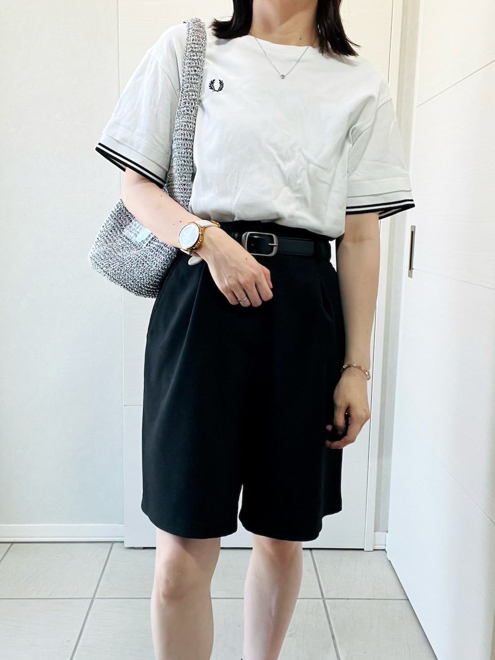 ブラック系のその他パンツ、ホワイト系のTシャツ/カットソー、シルバー系のショルダーバッグを着用したレディースの夏コーディネートの2枚目の写真