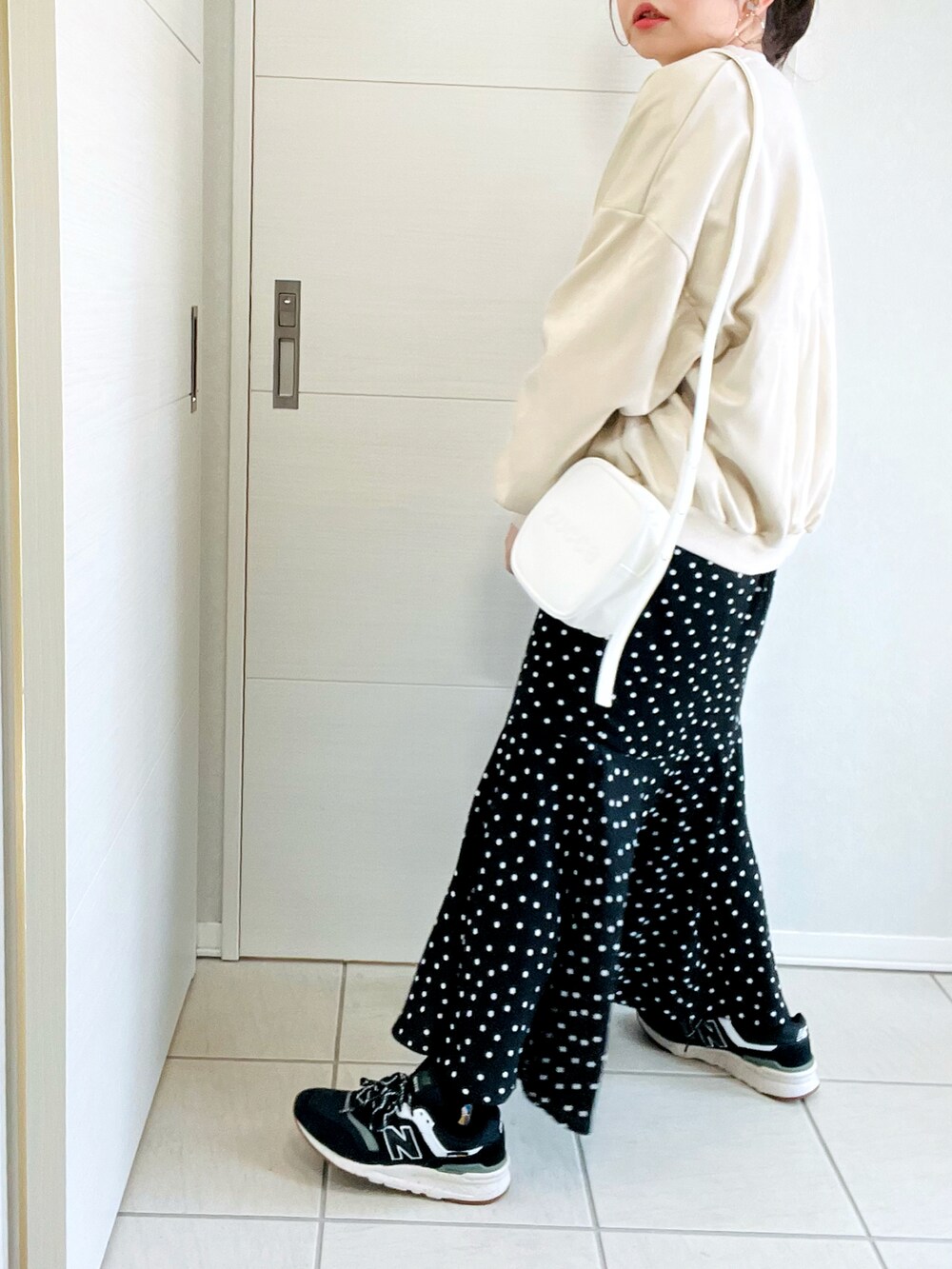 ホワイト系のスタジャン、ホワイト系のTシャツ/カットソー、ブラック系のスカートを着用したレディースの春コーディネートの4枚目の写真