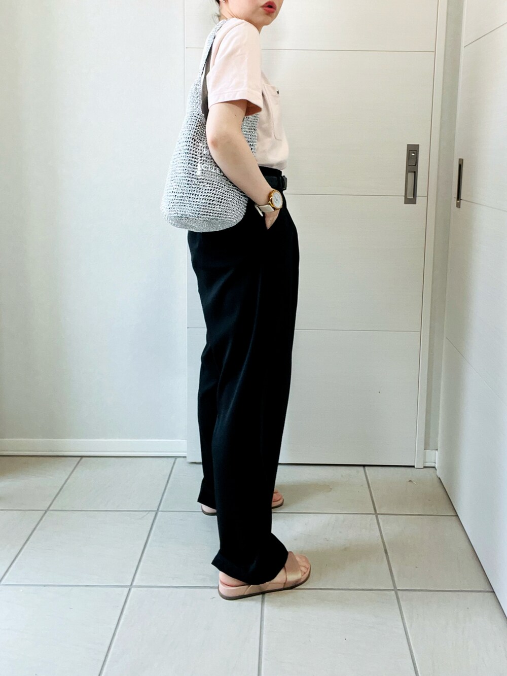 ブラック系のスラックス、ピンク系のTシャツ/カットソー、シルバー系のショルダーバッグを着用したレディースの夏コーディネートの5枚目の写真