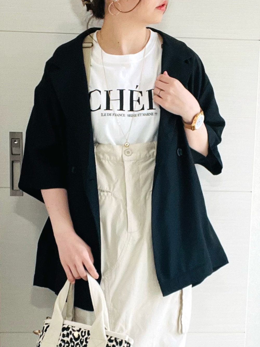 ホワイト系のTシャツ/カットソー、ブラック系のシャツ/ブラウス、ホワイト系のスカートを着用したレディースの春コーディネートの3枚目の写真