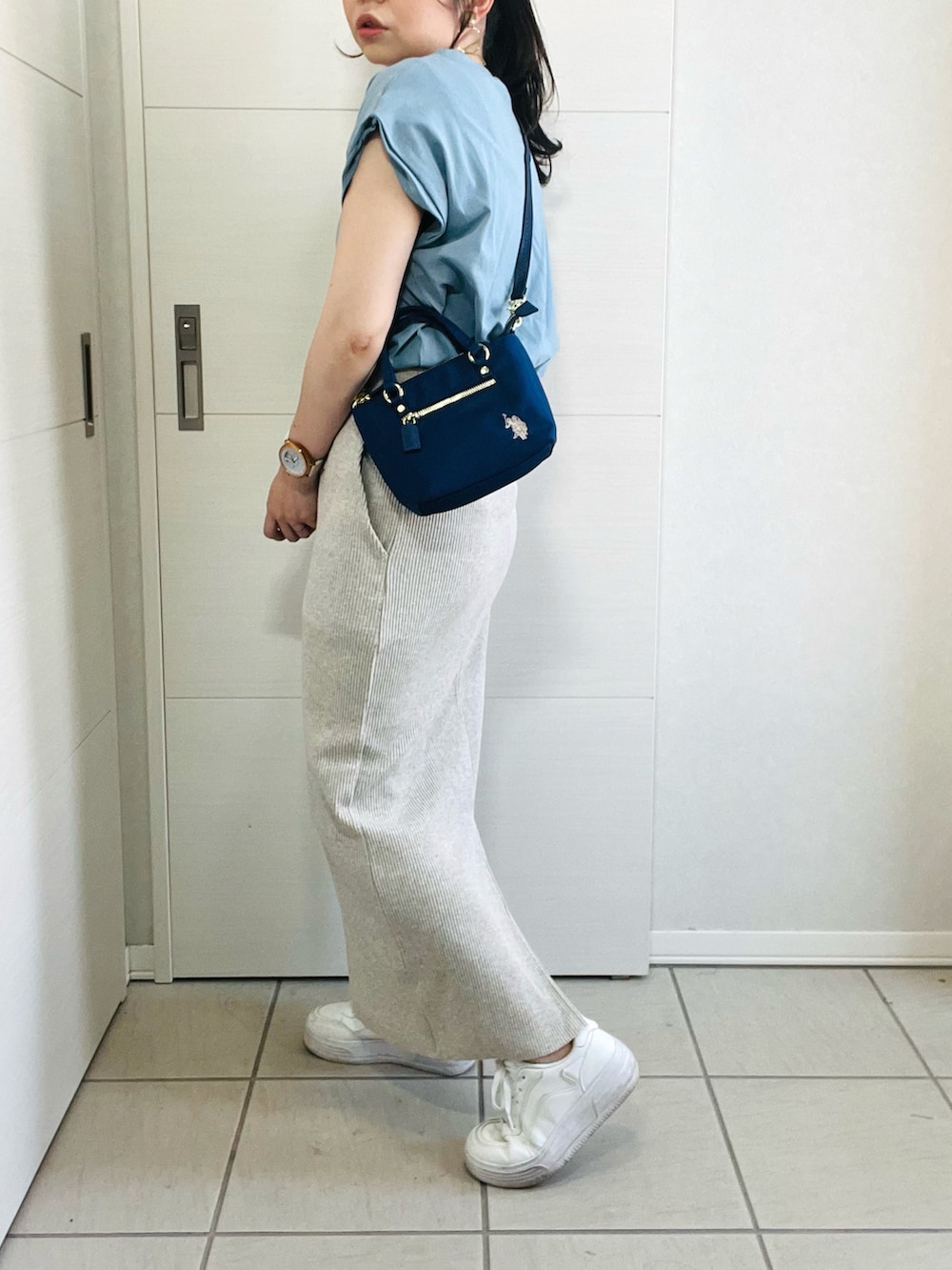 ブルー系のTシャツ/カットソー、ベージュ系のスカート、ホワイト系のスニーカーを着用したレディースの夏コーディネートの3枚目の写真