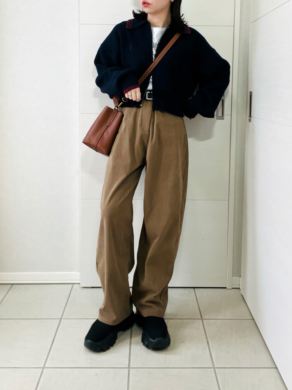 ブルー系のニット/セーター、ベージュ系のその他パンツ、ブラック系のブーツを着用したレディースの冬コーディネートの2枚目の写真