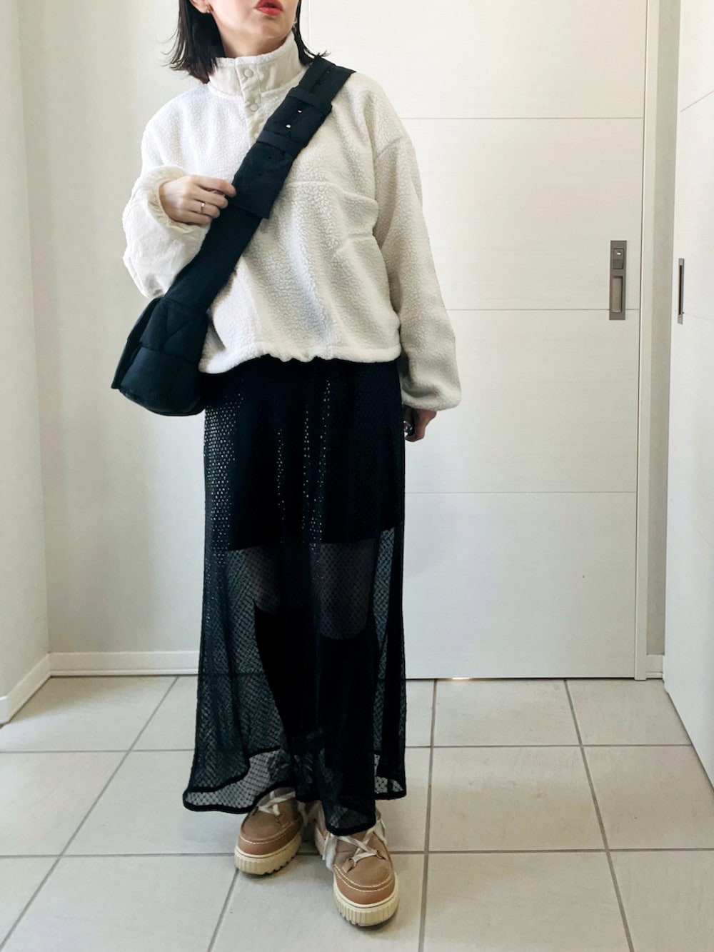 ホワイト系のTシャツ/カットソー、ブラック系のスカート、ブラウン系のブーツを着用したレディースの冬コーディネートの4枚目の写真