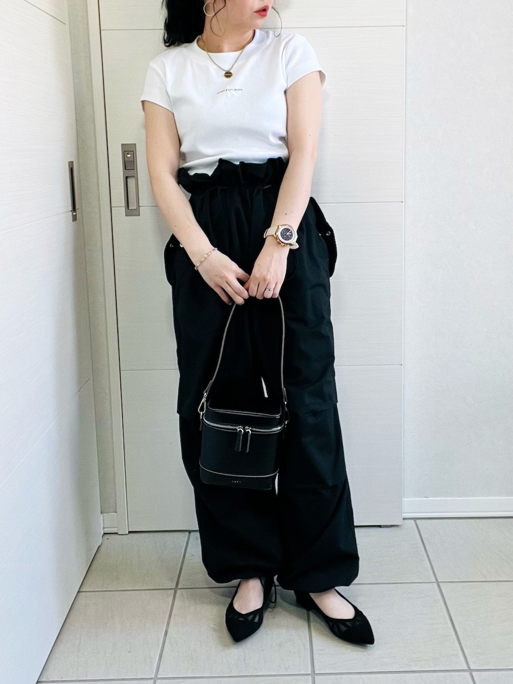 ホワイト系のTシャツ/カットソー、ブラック系のカーゴパンツ、ブラック系のパンプスを着用したレディースの春コーディネートの4枚目の写真