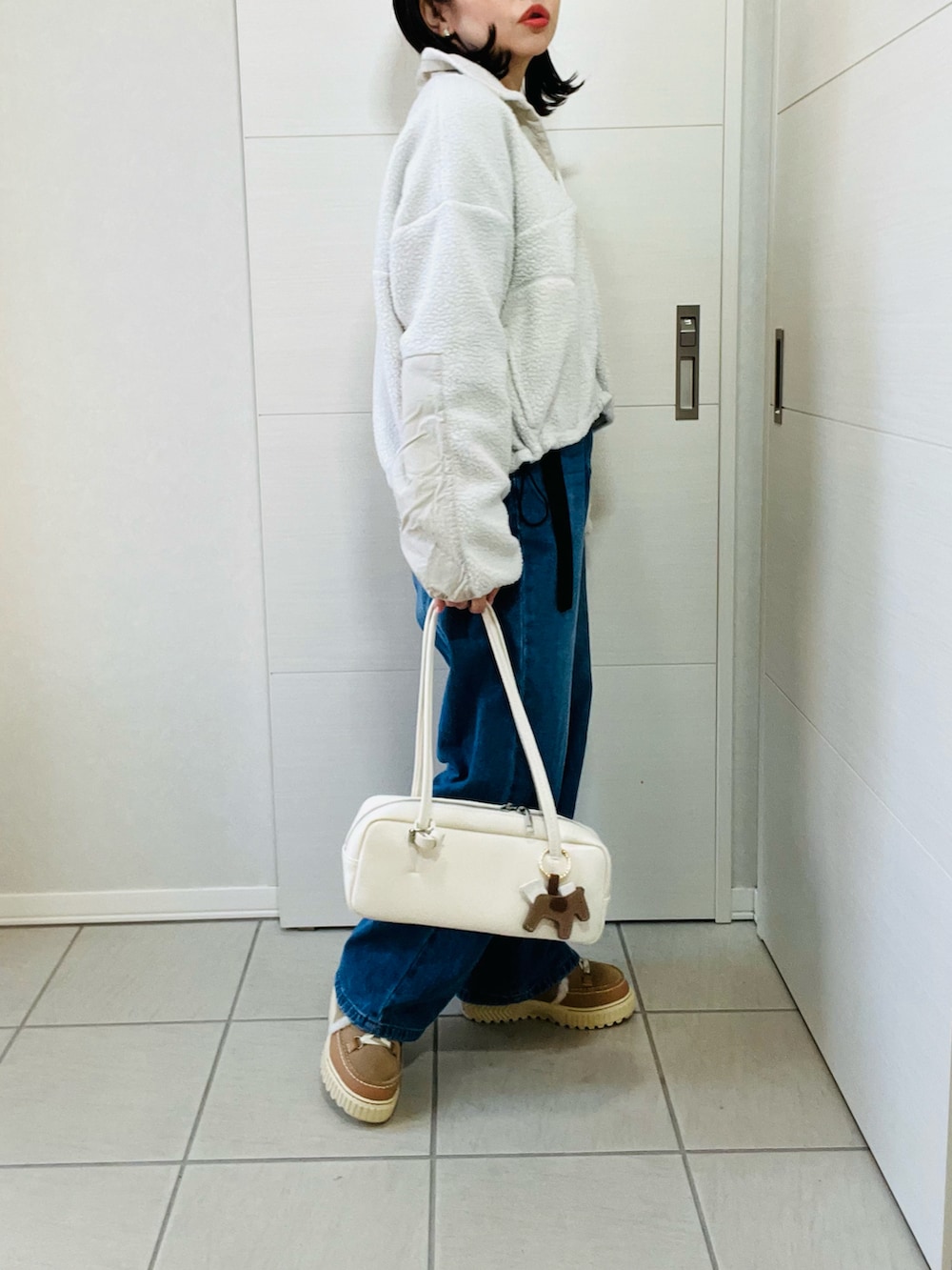 ホワイト系のTシャツ/カットソー、ブルー系のデニムパンツ、ブラウン系のブーツを着用したレディースの冬コーディネートの4枚目の写真