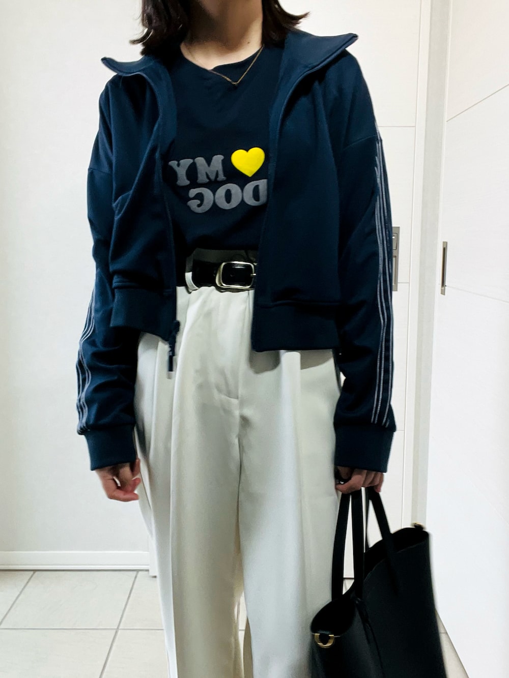 ブルー系のブルゾン、ホワイト系のスラックス、ブラック系のスニーカーを着用したレディースの秋コーディネートの2枚目の写真