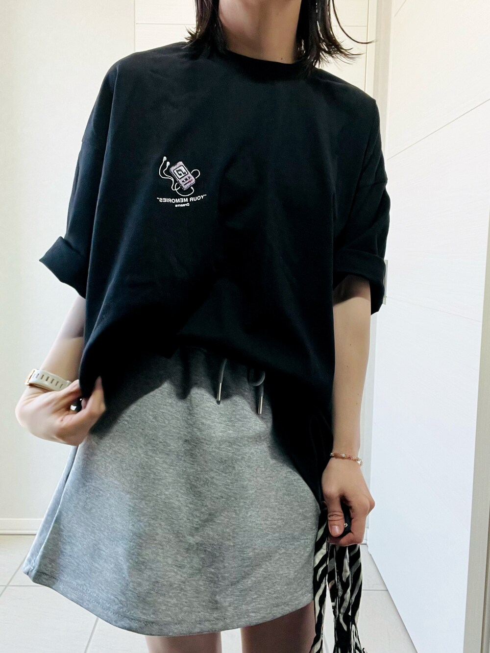 ブラック系のTシャツ/カットソー、ホワイト系のスニーカー、ブラック系のトートバッグを着用したレディースの春コーディネートの5枚目の写真