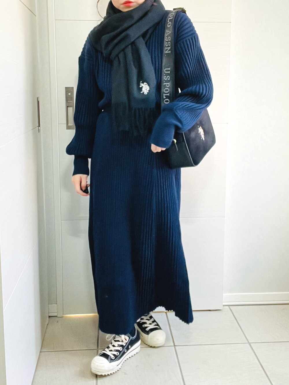 ブルー系のニット/セーター、ブルー系のスカート、ブラック系のスニーカーを着用したレディースの秋コーディネートの2枚目の写真