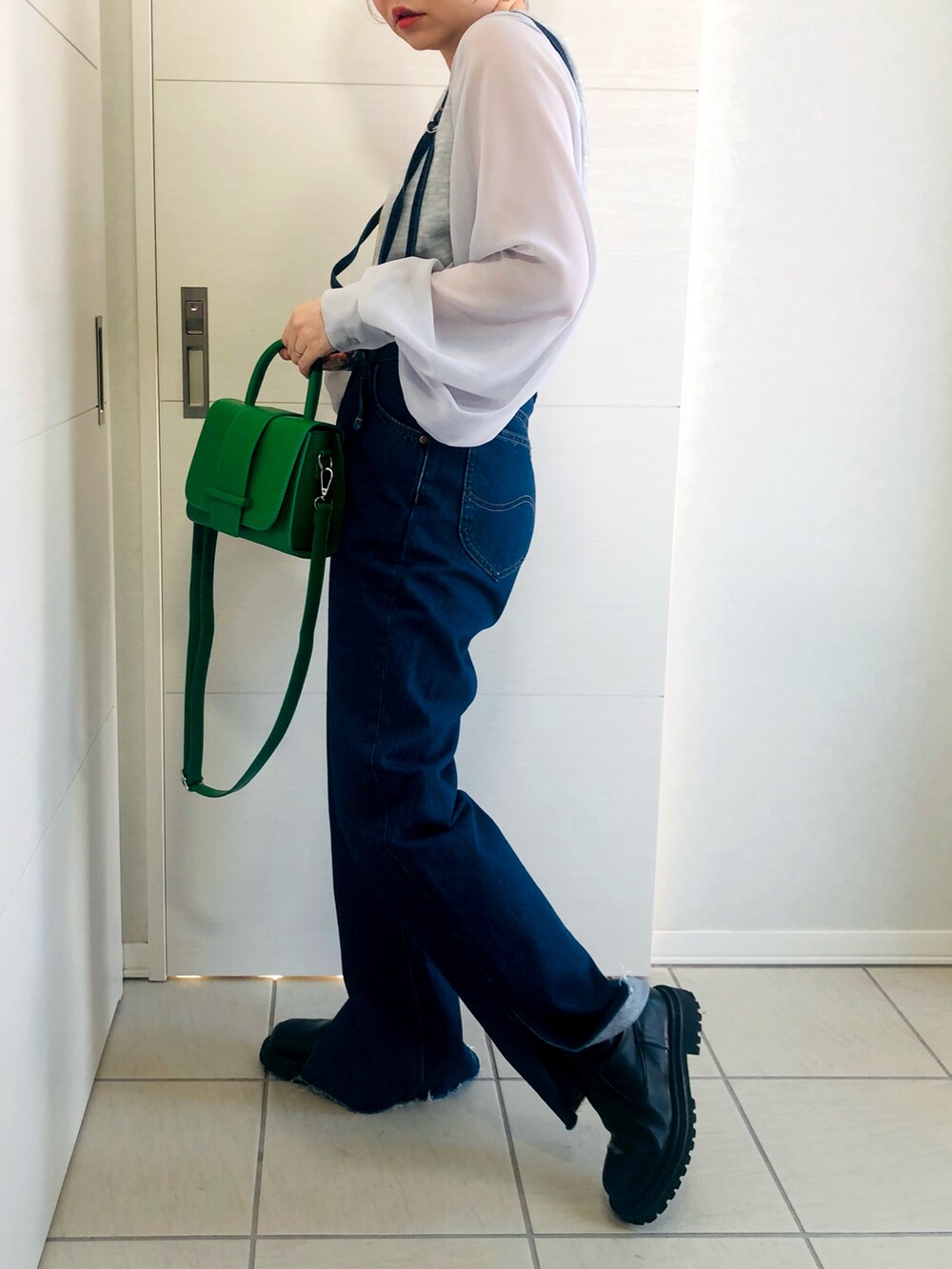 グレー系のTシャツ/カットソー、ブルー系のデニムパンツ、ブラック系のブーツを着用したレディースの冬コーディネートの3枚目の写真