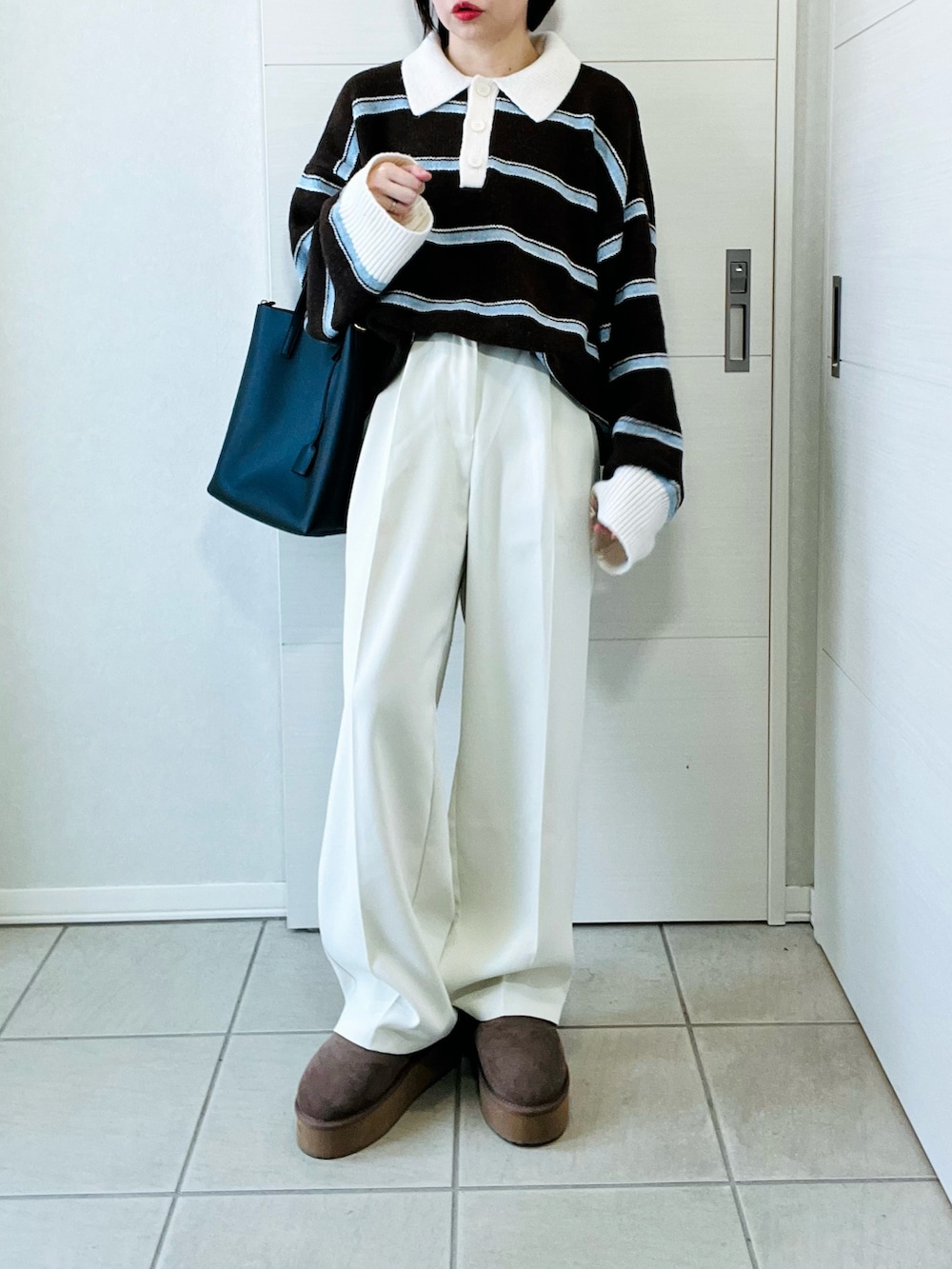 ベージュ系のスリッポン、ブラウン系のニット/セーター、ホワイト系のスラックスを着用したレディースの冬コーディネートの4枚目の写真