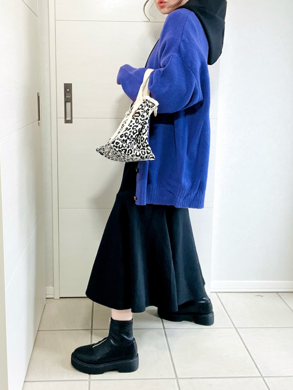 ブラック系のワンピース、パープル系のカーディガン/ボレロ、ブラック系のブーツを着用したレディースの秋コーディネートの5枚目の写真