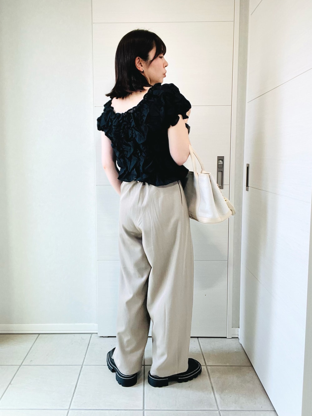 ブラック系のシャツ/ブラウス、ベージュ系のその他パンツ、ホワイト系のトートバッグを着用したレディースの夏コーディネートの4枚目の写真